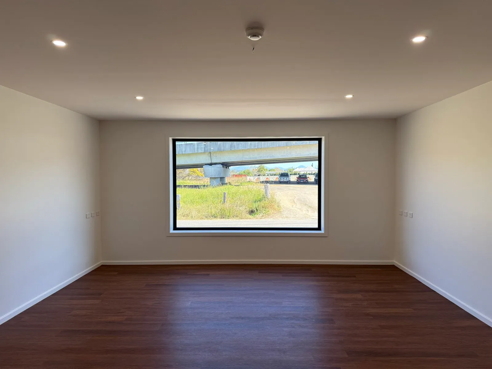Picture window in the works depot office framing the highway overpass and depot yard, Macksville